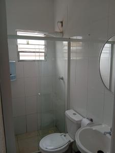 a white bathroom with a toilet and a sink at Apartamento 45A in Paulínia