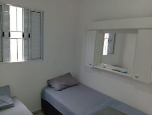a white room with a bed and a window at Apartamento 45A in Paulínia
