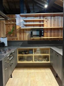 a kitchen with wooden cabinets and a microwave at 赤瓦のお宿みあげむい in Kunigami