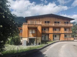a wooden house with a balcony on the side of a road at Levio Homes Sunny Alpine Apartments with Balconies in Haus im Ennstal