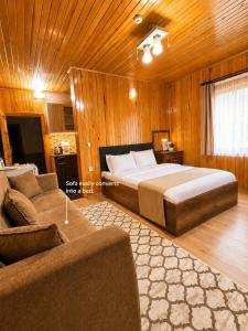 a bedroom with a large bed and a couch at Han PANSİYON in Çaykara +74 photos