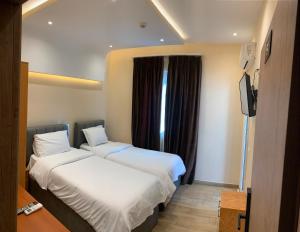 a hotel room with two beds and a television at SR99 Hotel in Tirana