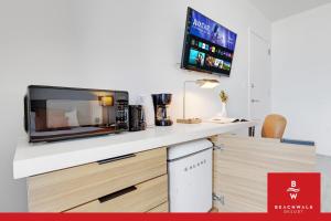 a kitchen with a microwave and a tv on a counter at Upper-Floor Studio Balcony Sleeps 4 in Hallandale Beach