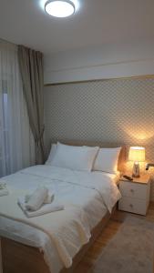 a bedroom with a large white bed and a lamp at Astera 4 in Vrnjci