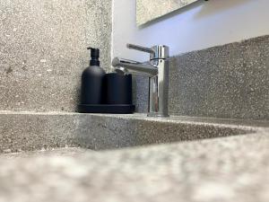 a soap dispenser sitting next to a bathroom sink at Fandara Suites in Turin +48 photos