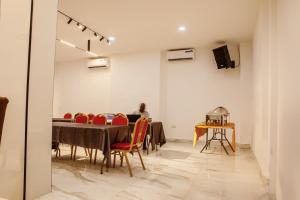 ein Esszimmer mit einem Tisch und roten Stühlen in der Unterkunft Romeneo Grand Royal Hotel in Lagos