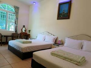 a hotel room with two beds and a window at Taitung Moon House in Luye