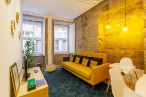 ポルトにあるOld Stone Flats by Host Wiseの黄色いソファとテーブルのあるリビングルーム