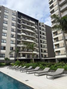 a row of lounge chairs in front of a building at Summers luxury at Bantree in Accra