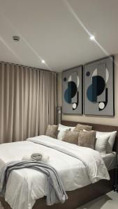 a bedroom with a large white bed with two pictures on the wall at Summers luxury at Bantree in Accra
