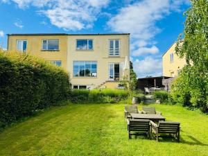 a table and benches in front of a building at Cozy and Spacious Guest Room, Virum in Virum