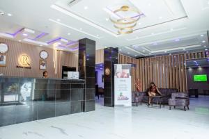 Eine Frau sitzt an einem Schreibtisch in einer Lobby in der Unterkunft Romeneo Grand Royal Hotel in Lagos