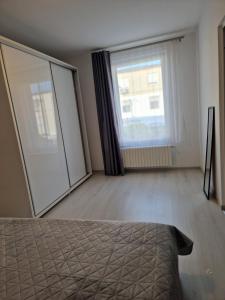 a bedroom with a bed and a large window at Iris ultracentral apartment in Mangalia
