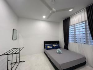 a white room with a bed and a window at Seroja Homestay Gopeng in Gopeng