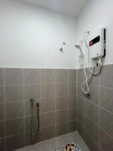 a shower in a bathroom with a shower head at Seroja Homestay Gopeng in Gopeng