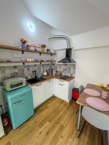 a small kitchen with a blue stove and a table at Barevný úlet - Písek in Písek