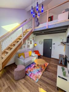 a living room with a couch and stairs at Barevný úlet - Písek in Písek
