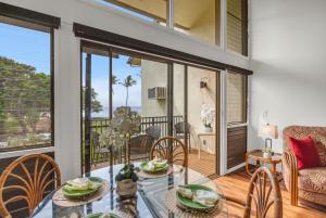 a dining room with a glass table and chairs at Makani A Kai B11 in Wailuku +27 photos