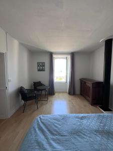 a bedroom with a bed and a desk and a window at Ker Lucie in Crozon