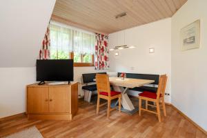 a dining room with a table and a television at Ferienhaus Enzi in Weissbriach
