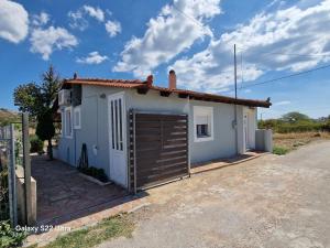 a small white house with a garage at komi's family house in Kómi