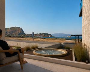 a person sitting in a chair on a patio at Harmony Hotel Nafplio in Nafplio