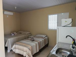 a small room with two beds and a sink at Casa Studio Uirá - rua dos Cravos in Chapada dos Guimarães +10 photos