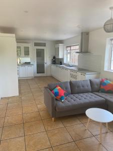 a living room with a couch and a kitchen at Daline House Clonakilty in Clonakilty