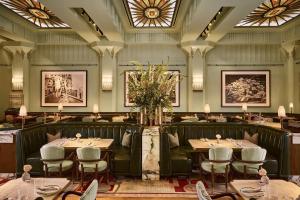 a dining room with tables and chairs and windows at Claridge's, Maybourne in London