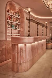 a bar in a restaurant with a shelf of wine bottles at Claridge's, Maybourne in London