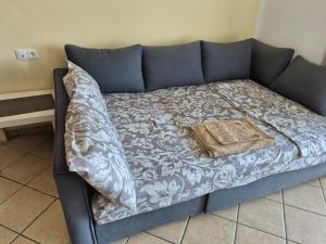 a blue couch with a blanket on top of it at Cabo dream 75 piscine et wifi in Cabo Negro