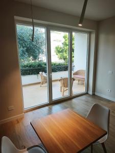 a dining room with a wooden table and glass doors at Le Lenze in Pozzilli