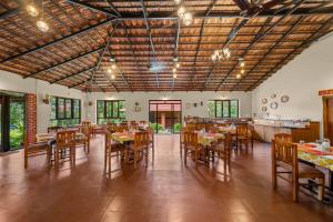a large dining room with tables and chairs at Magnolia Estates & Resorts in Virajpet