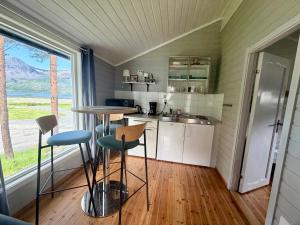 a small kitchen with a table and chairs in a room at Mørsvikbotn Camping AS in Mørsvik +4 photos