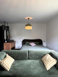 a bedroom with a green couch and a bed at uBa Vineyard Stay con vistas al Miño Ribeira Sacra in Chantada