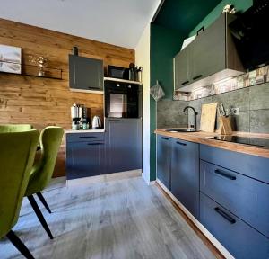 a kitchen with blue cabinets and green walls at Vossenstuuv in Goslar