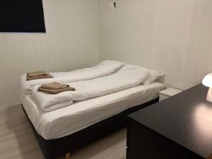 a bed with white sheets and towels on it at Modern basement apartment, 65 square meters in Alta