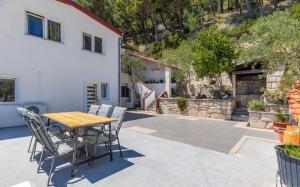 a patio with a wooden table and chairs at Miljak in Duće