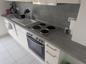 a kitchen with a stove top oven next to a sink at Private Apartment centrally located in Grafenwöhr
