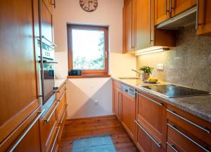 a kitchen with wooden cabinets and a sink and a window at Haus Uschi in Klagenfurt