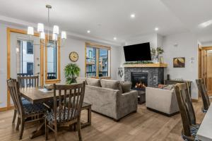 a living room with a couch and a table and a fireplace at Luxury Mountain Haven Views Hot Tub Central Bridgette Bar Main St in Canmore