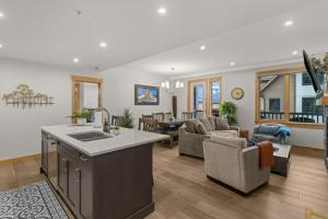 a living room with a kitchen and a living room with a couch at Luxury Mountain Haven Views Hot Tub Central Bridgette Bar Main St in Canmore