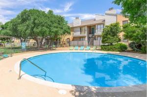 a large blue swimming pool in front of a building at District West 2BR near shopping & dining in Lubbock