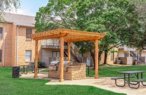 a wooden pergola with a grill in a yard at District West 2BR near shopping & dining in Lubbock
