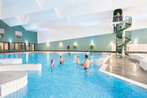 a group of people in a swimming pool at Villa Relax Ooghduyne - Dünen Golf und Spa bei Beach & more in Julianadorp