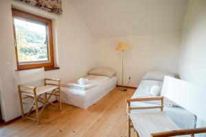 a room with a bed and two chairs and a window at Haus Uschi in Klagenfurt