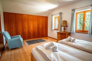 a bedroom with two beds and a blue chair at Haus Uschi in Klagenfurt