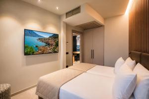 a bedroom with a white bed with a picture on the wall at Eos Lake House Luxury in Limone sul Garda