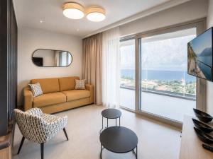 a living room with a couch and a large window at Eos Lake House Luxury in Limone sul Garda