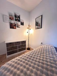 a bedroom with a bed and a dresser and pictures on the wall at Vossenstuuv in Goslar